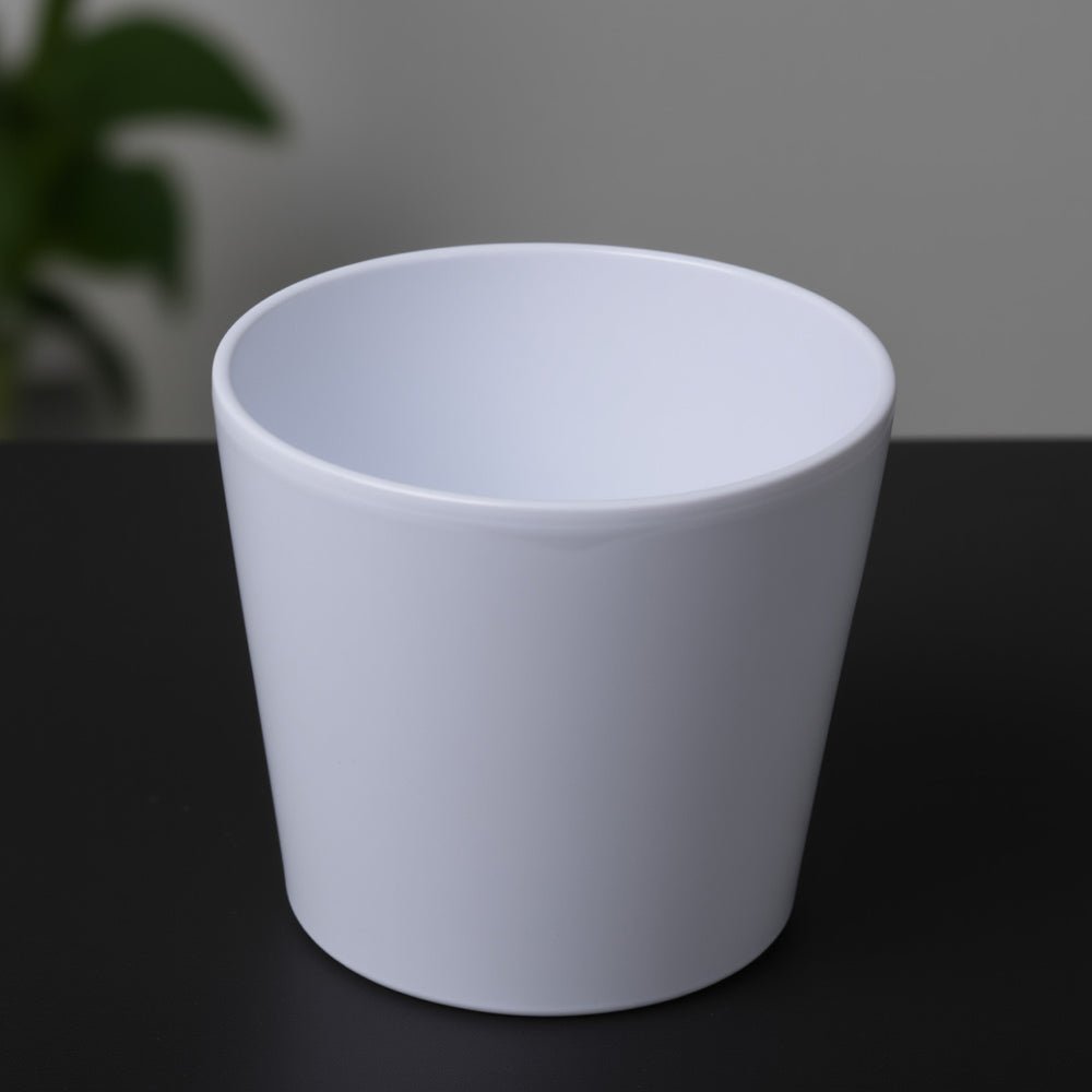 Indoor houseplant pots featuring a white ceramic plant pot with a smooth minimalist design, ideal for modern indoor plant displays.