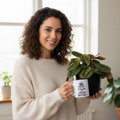 Woman holding a Maranta Prayer Plants and a mug with text in a bright indoor setting